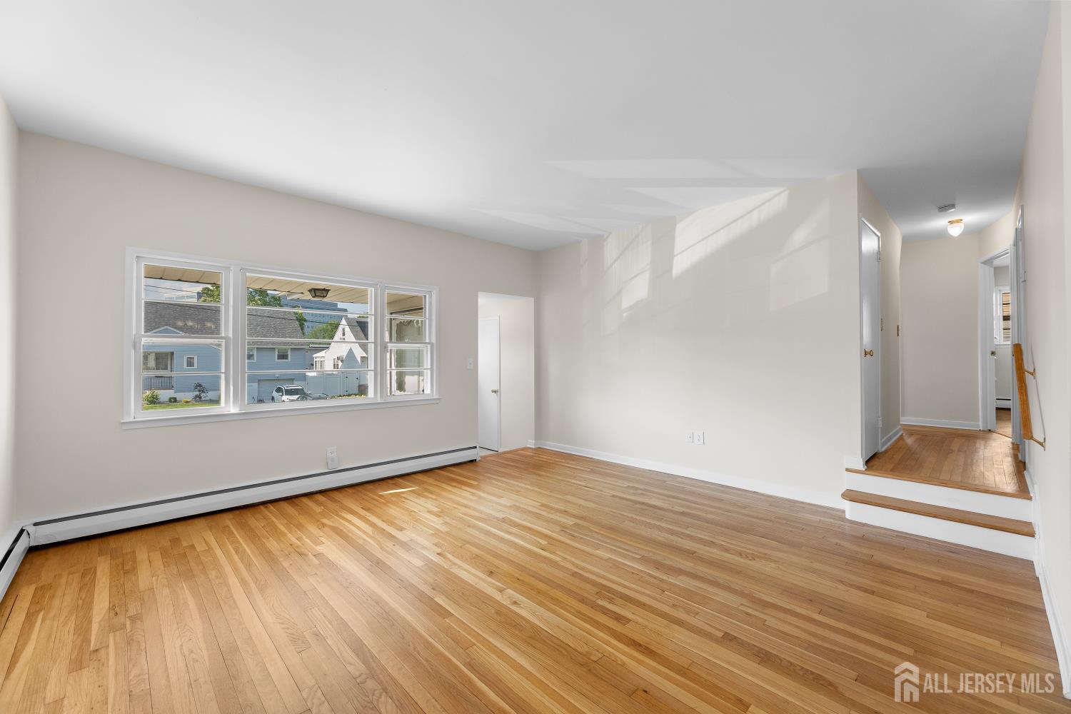 82 Mercer Street Menlo Park Terrace, NJ 08840 - Photo 7 of 31 a view of an empty room with wooden floor and a window