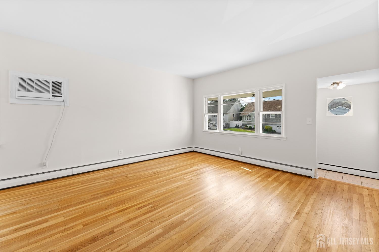 82 Mercer Street Menlo Park Terrace, NJ 08840 - Photo 9 of 31 an empty room with wooden floor and windows