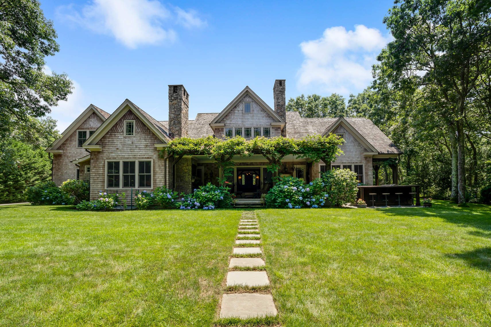 a front view of a house with yard and green space