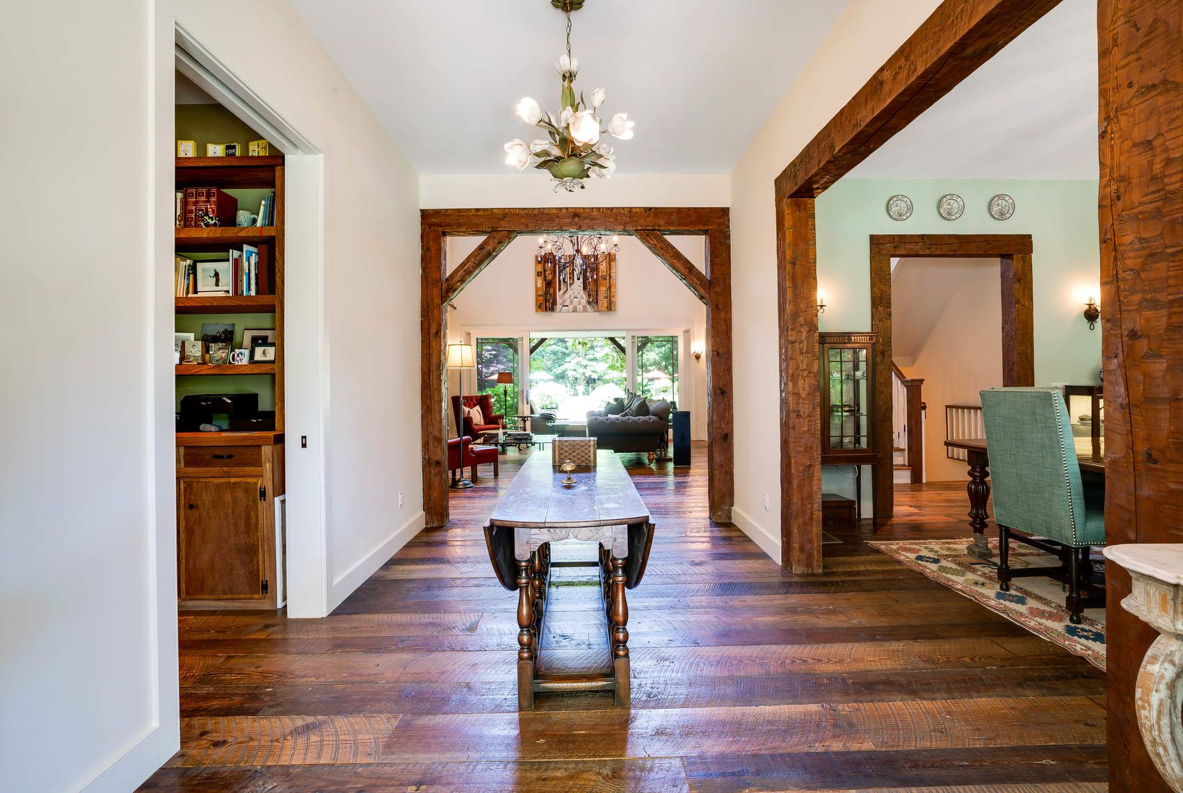 118 NW Path Sagaponack, NY 11962 - Photo 9 of 18 a dining room with wooden floor a chandelier a glass table and chairs