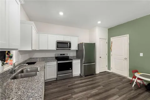 a kitchen with granite countertop a refrigerator stove and microwave