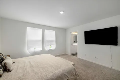 a bedroom with a large bed and a flat screen tv