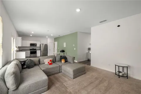 a living room with furniture and kitchen view