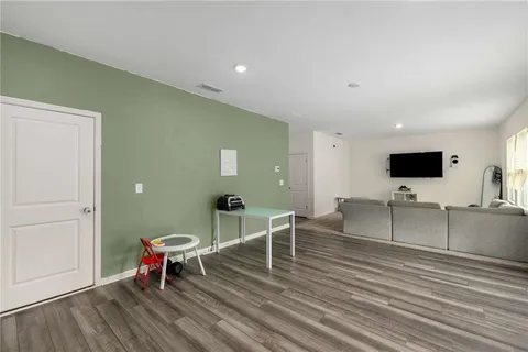 a living room with furniture a flat screen tv and kitchen view