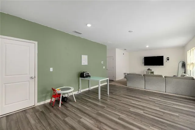 a living room with furniture a flat screen tv and kitchen view
