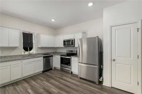 a kitchen with stainless steel appliances granite countertop a refrigerator sink and stove