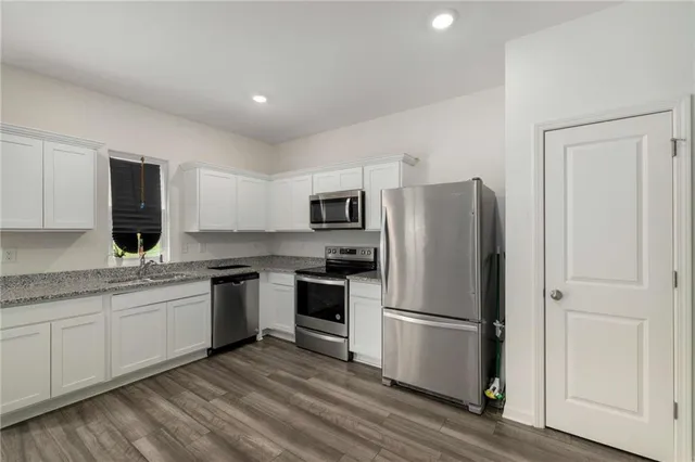a kitchen with stainless steel appliances granite countertop a refrigerator sink and stove