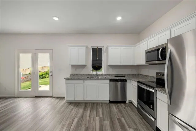a kitchen with stainless steel appliances granite countertop a stove a sink and a refrigerator