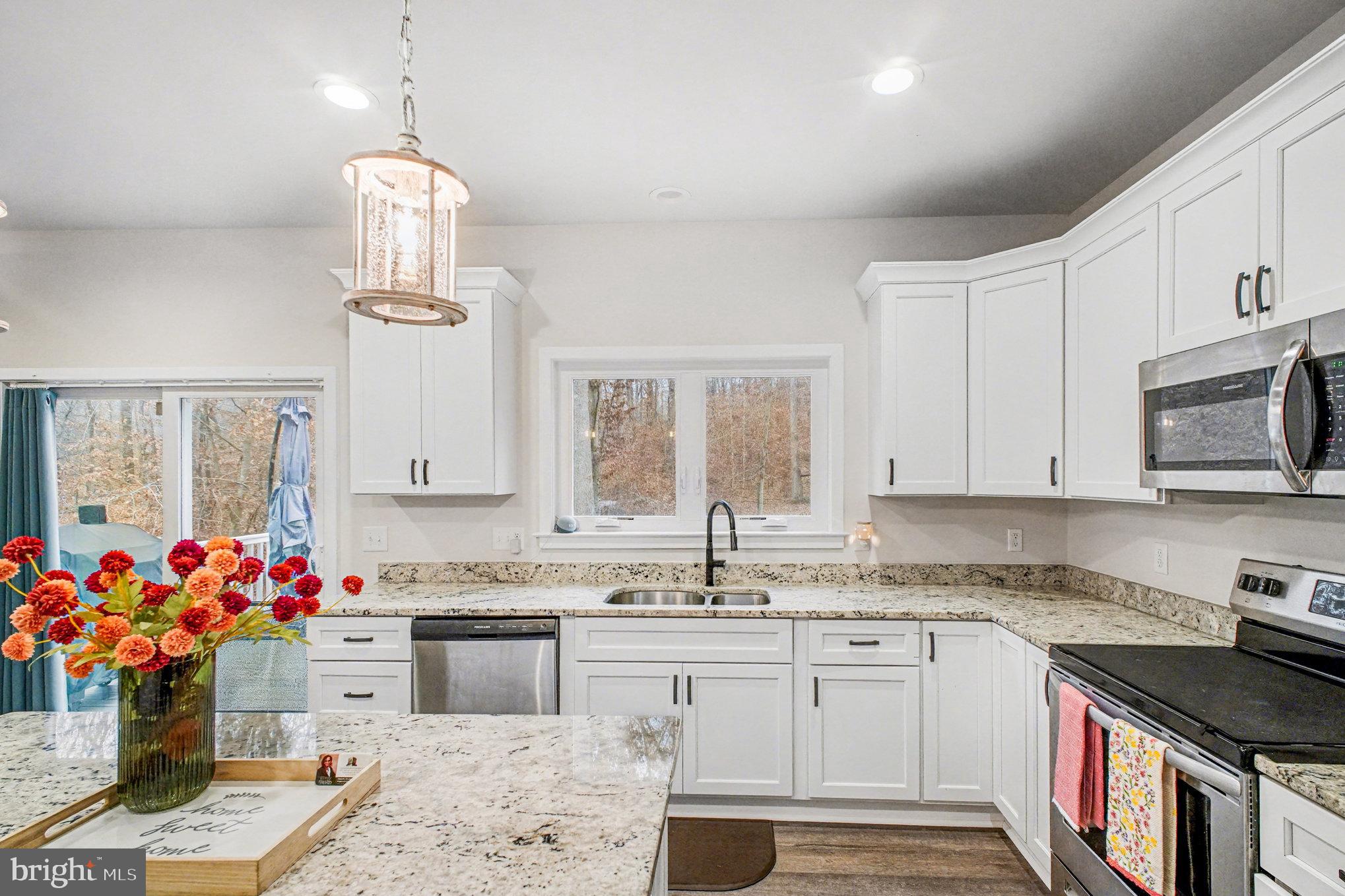 580 Kellogg Mill Road Fredericksburg, VA 22406 - Photo 12 of 41 a kitchen with granite countertop a sink stove and white cabinets