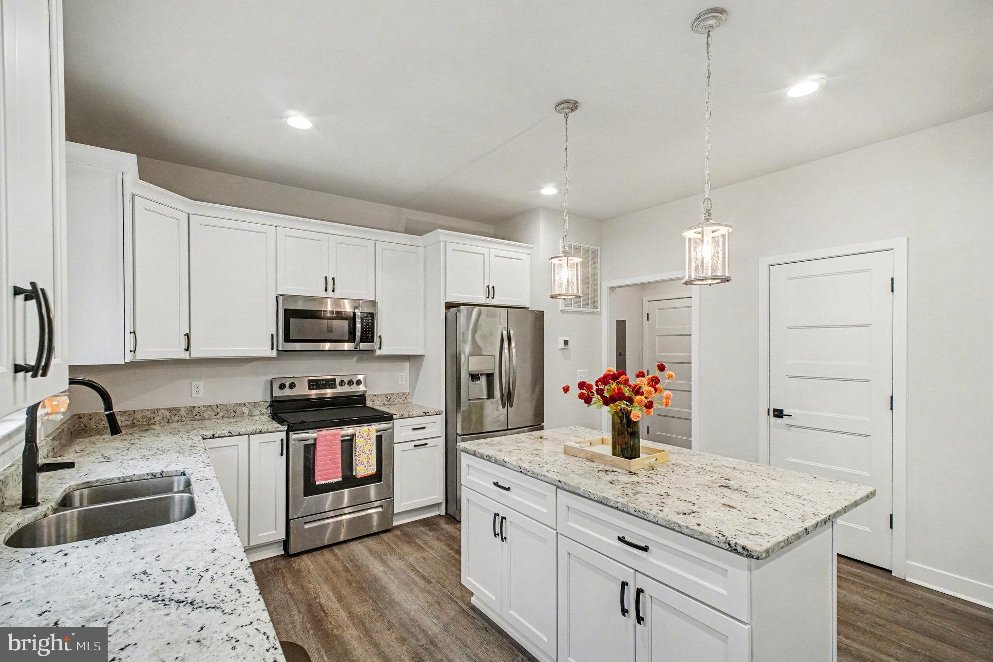 580 Kellogg Mill Road Fredericksburg, VA 22406 - Photo 10 of 41 a kitchen with stainless steel appliances granite countertop a sink dishwasher a refrigerator and white cabinets with wooden floor