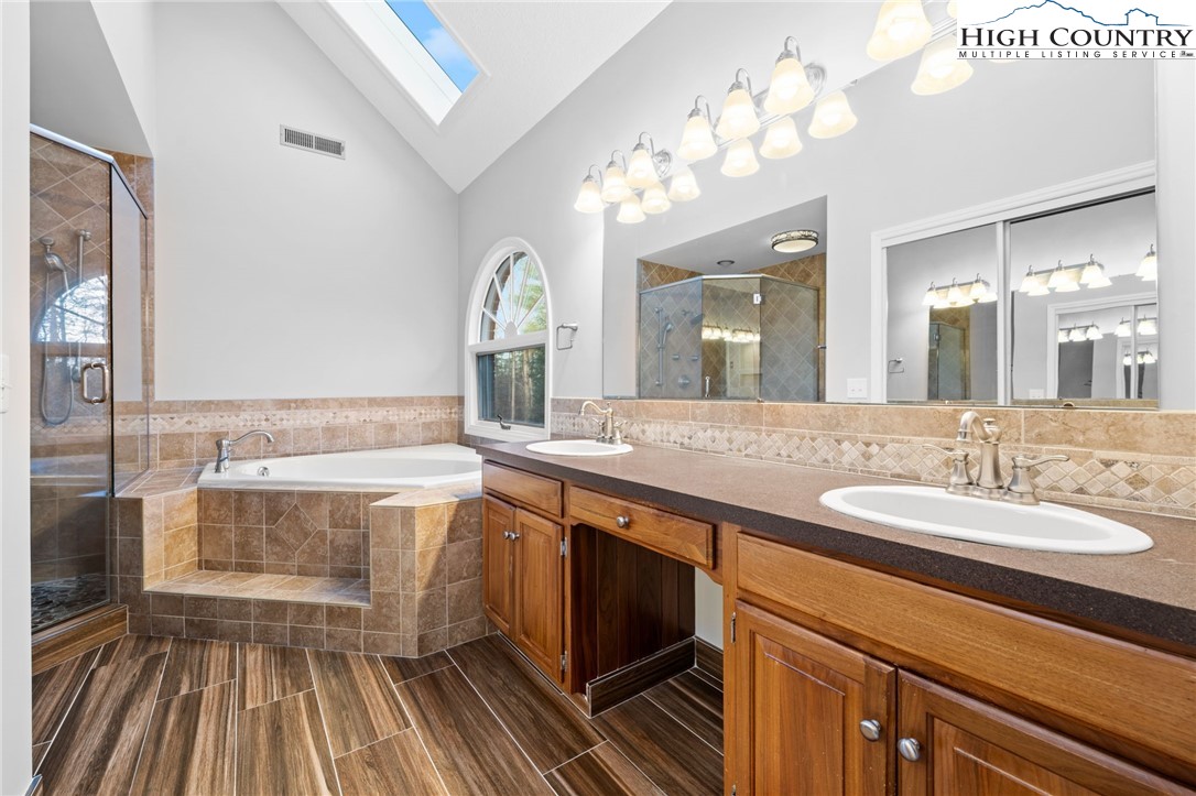 458 Jim Caudill Road Wilkesboro, NC 28697 - Photo 22 of 50 a spacious bathroom with a granite countertop sink a toilet a mirror and bathtub