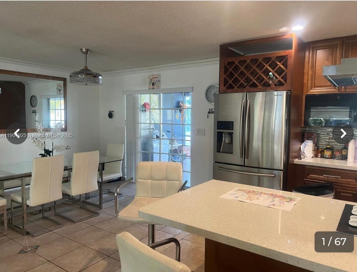 5001 Madison Street Hollywood, FL 33021 - Photo 1 of 23 a kitchen with stainless steel appliances a refrigerator and a dining table