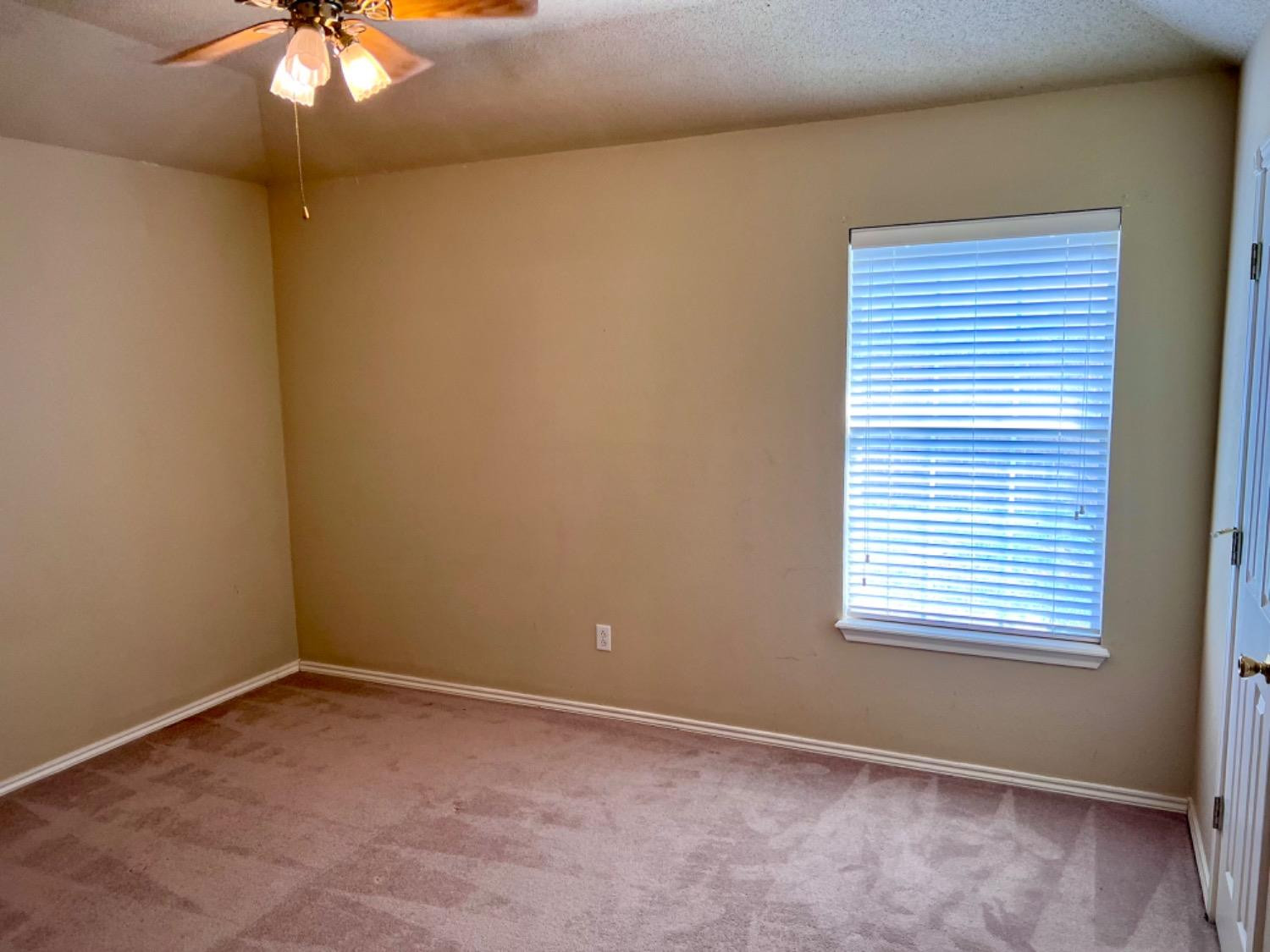 405 Sooner Street Wolfforth, TX 79382 - Photo 11 of 24 an empty room with a window and a chandelier fan