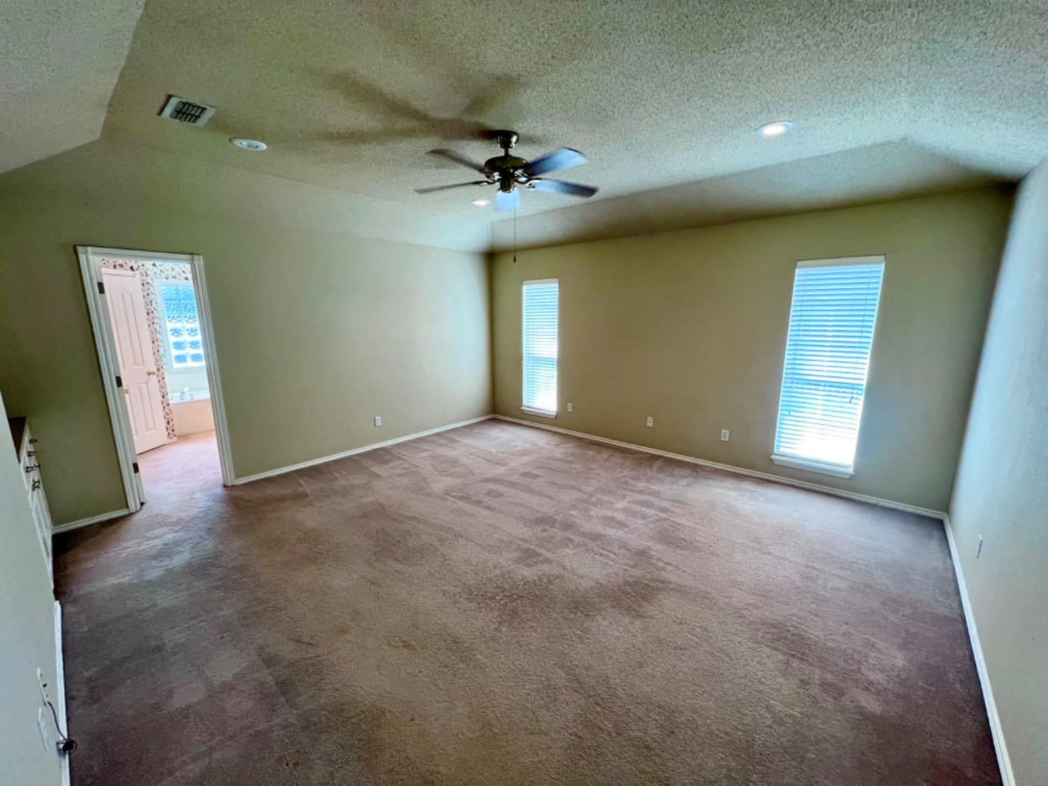 405 Sooner Street Wolfforth, TX 79382 - Photo 14 of 24 an empty room with a ceiling fan and window
