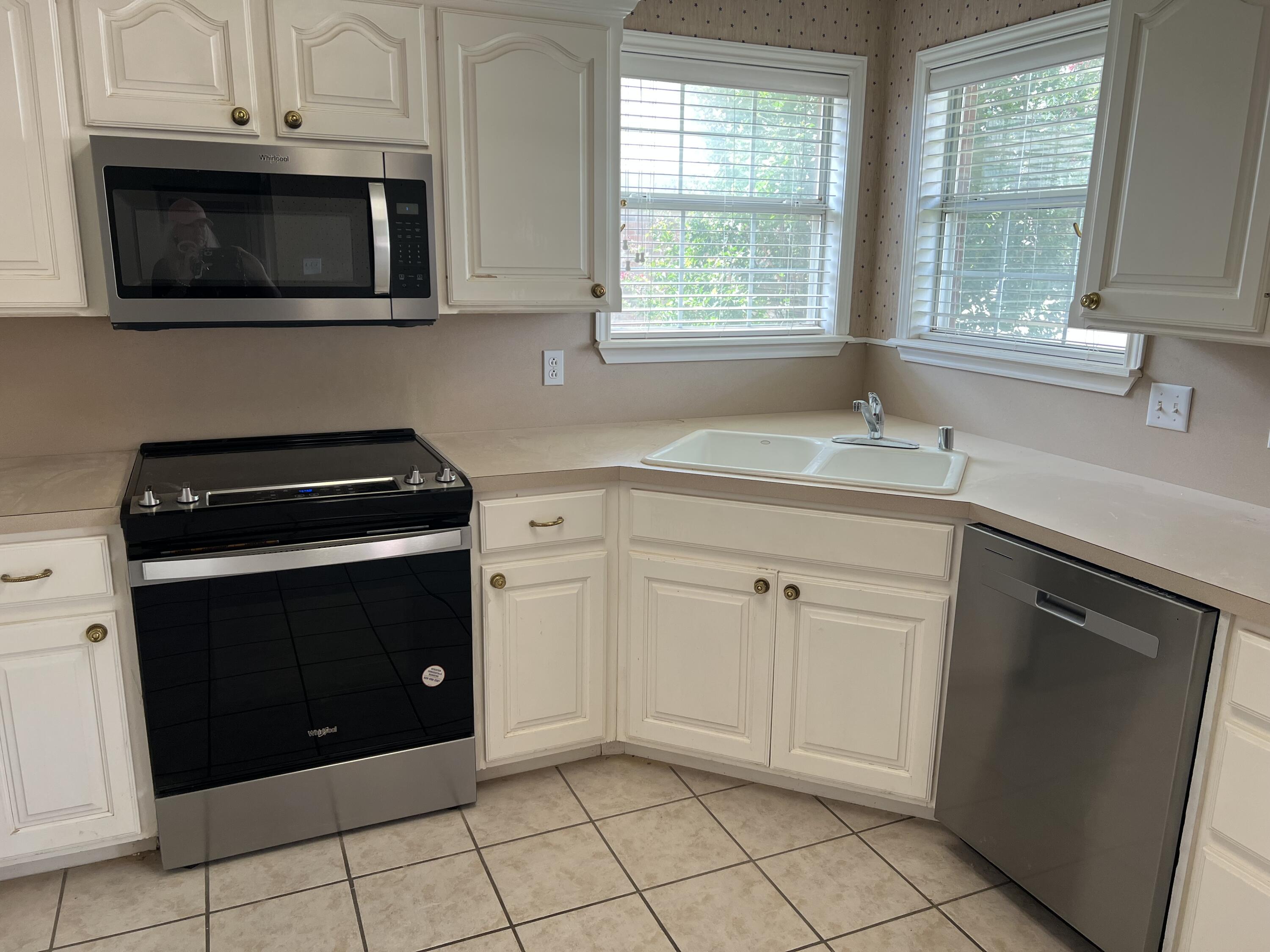 405 Sooner Street Wolfforth, TX 79382 - Photo 3 of 24 a kitchen with granite countertop white cabinets and black appliances
