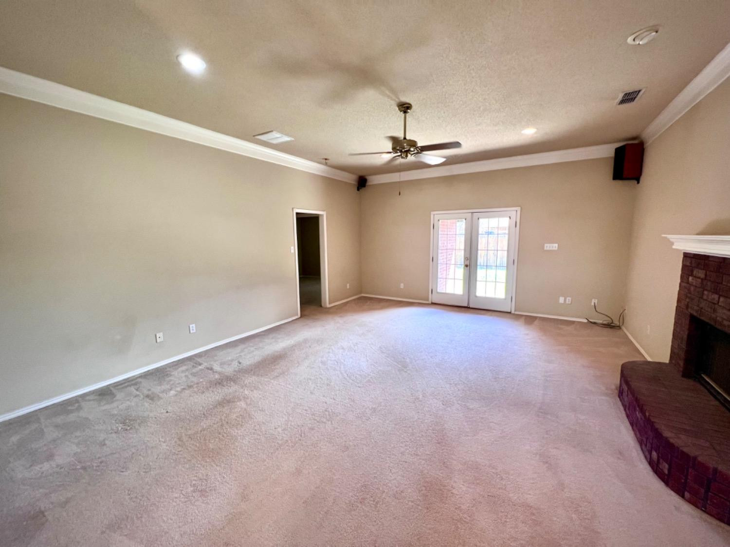 405 Sooner Street Wolfforth, TX 79382 - Photo 8 of 24 an empty room with windows and fireplace