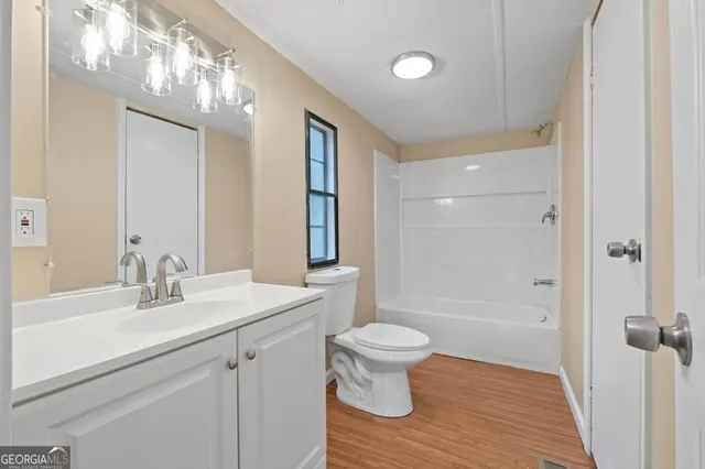 a bathroom with a sink toilet a mirror and shower