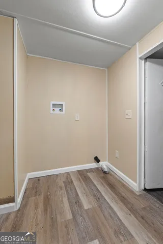 a view of a room with wooden floor and white walls