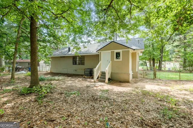 a view of a house with a yard and large tree