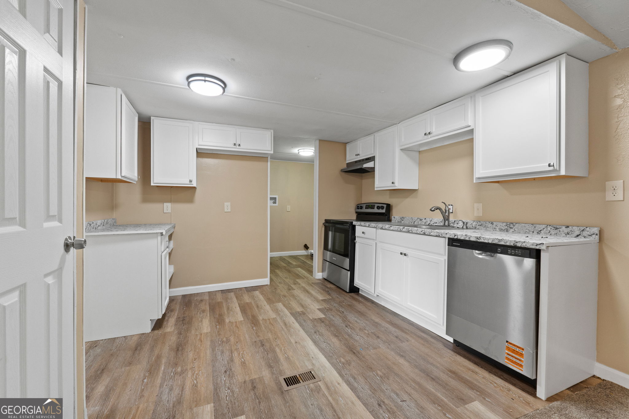 361 Hemlock Lane Locust Grove, GA 30248 - Photo 2 of 20 a kitchen with a refrigerator a stove top oven and wooden floor