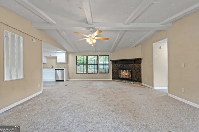 a view of an empty room with a fireplace and a window