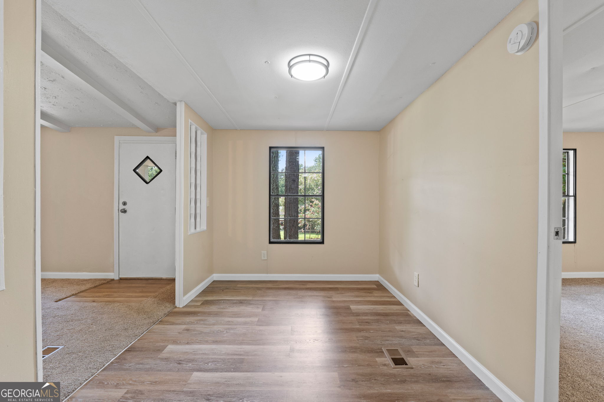 361 Hemlock Lane Locust Grove, GA 30248 - Photo 9 of 20 a view of an empty room with window and wooden floor