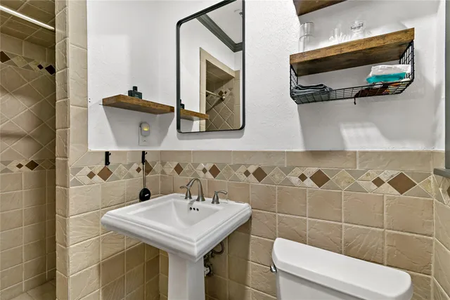 a bathroom with a sink a toilet and shower