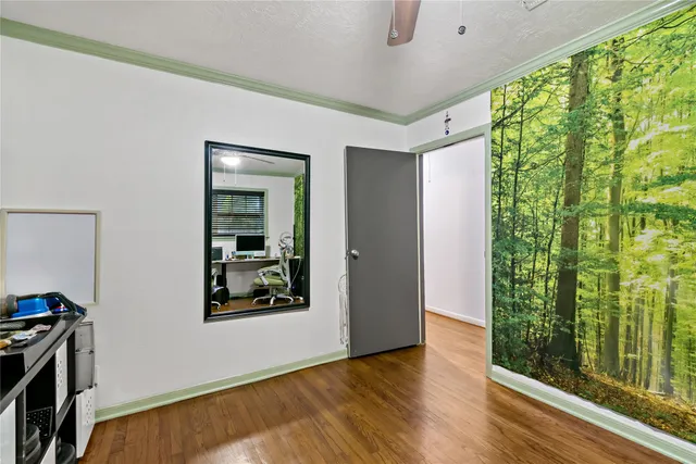 a view of an empty room with a window and wooden floor