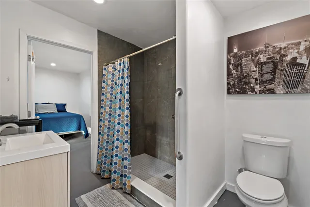 a bathroom with a sink a toilet and shower