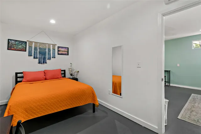 a bed sitting in a bedroom next to a window