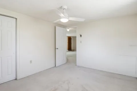 an empty room with a ceiling fan and bathroom