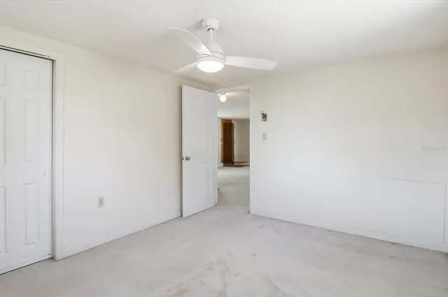 an empty room with a ceiling fan and bathroom