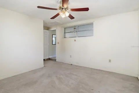 an empty room with closet and a chandelier fan