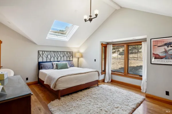 a kitchen with stainless steel appliances kitchen island granite countertop a refrigerator a sink a stove and white cabinets with wooden floor