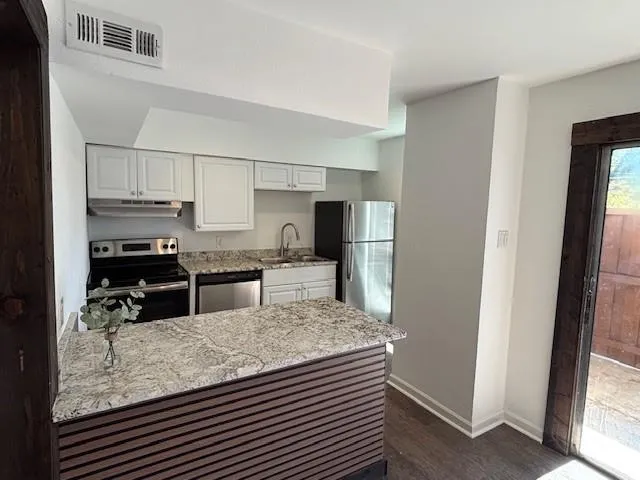 a kitchen with refrigerator and stove