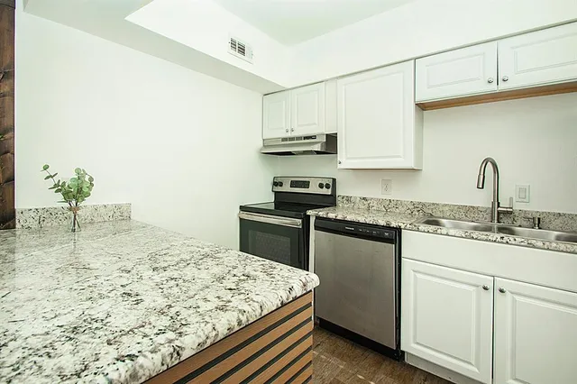 a kitchen with stainless steel appliances granite countertop a sink stove and cabinets