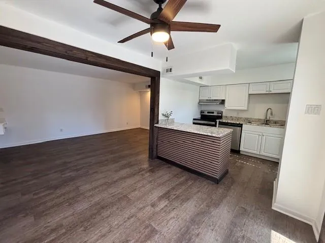 a kitchen with granite countertop wooden cabinets and white appliances