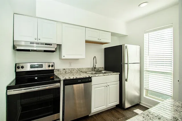 a kitchen with stainless steel appliances a stove a refrigerator and cabinets