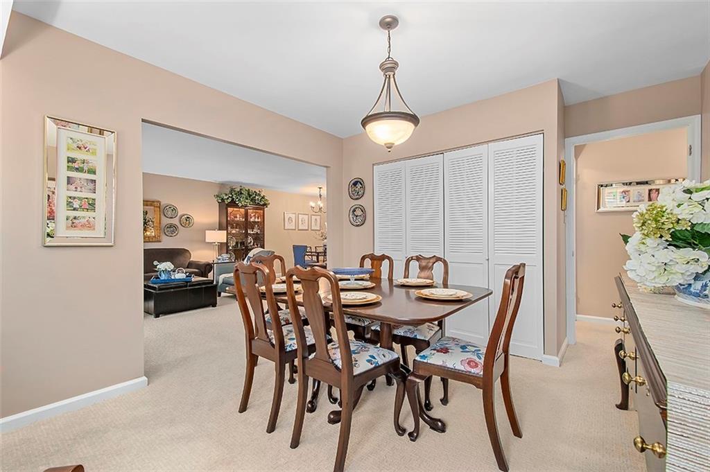 1500 Cochran Road, Unit 510 Pittsburgh, PA 15243 - Photo 13 of 25 a view of a dining room and livingroom with furniture wooden floor a rug a potted plant and a chandelier