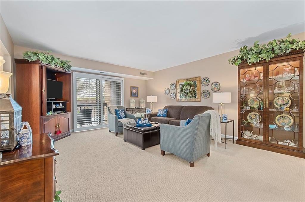 1500 Cochran Road, Unit 510 Pittsburgh, PA 15243 - Photo 5 of 25 a living room with furniture a flat screen tv and a floor to ceiling window
