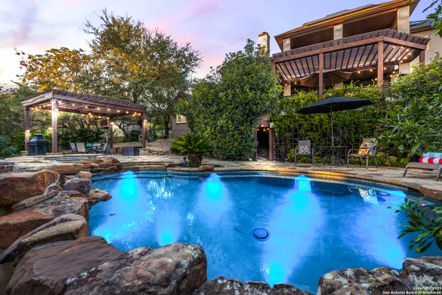 a view of a swimming pool with lawn chairs under an umbrella