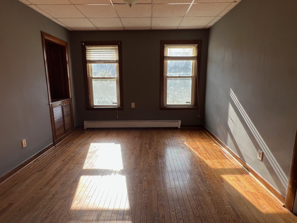 47 Acton Street Worcester, MA 01604 - Photo 13 of 30 an empty room with wooden floor and windows