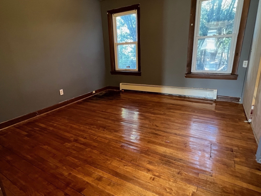 47 Acton Street Worcester, MA 01604 - Photo 15 of 30 an empty room with wooden floor and windows
