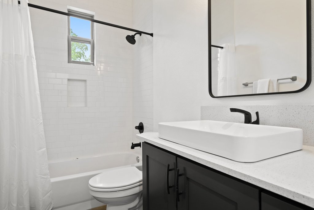 1131 Poquito Street, Unit A Austin, TX 78702 - Photo 28 of 34 a bathroom with a sink a toilet and a mirror