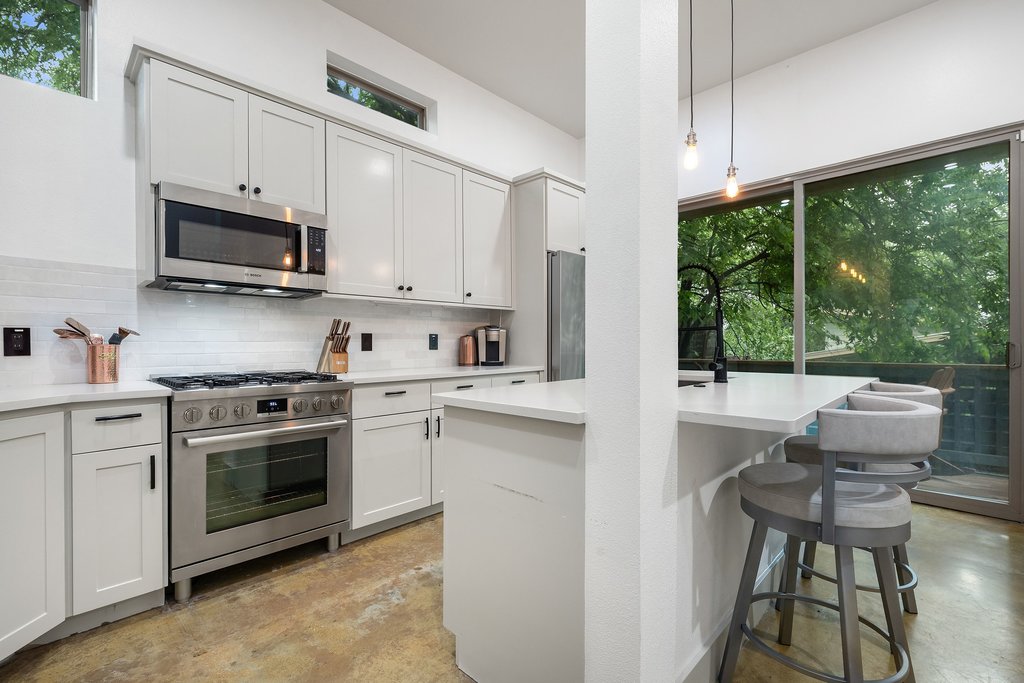 1131 Poquito Street, Unit A Austin, TX 78702 - Photo 10 of 34 a kitchen with stainless steel appliances granite countertop a stove a sink and a microwave