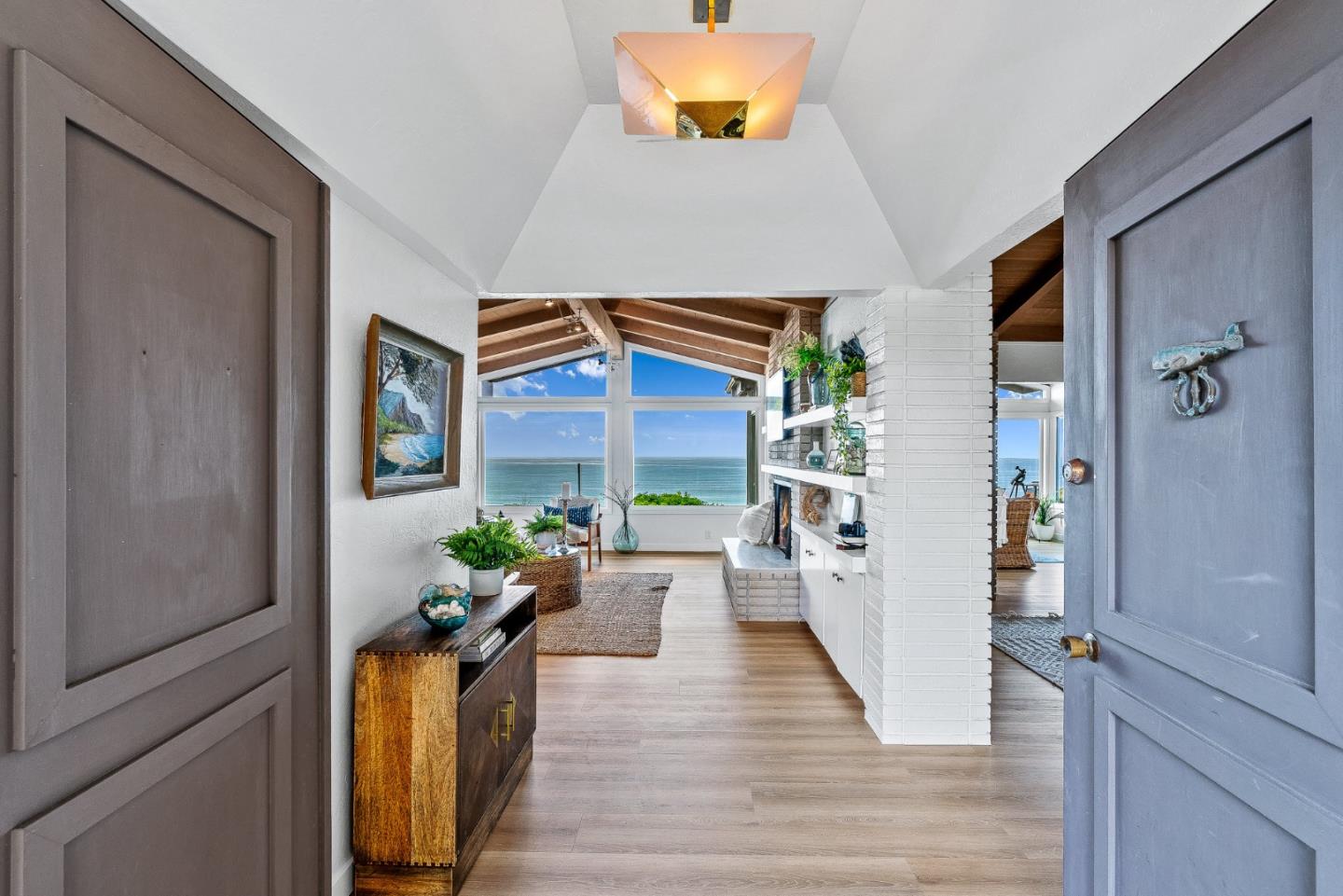 a hallway with wooden floor and a potted plant