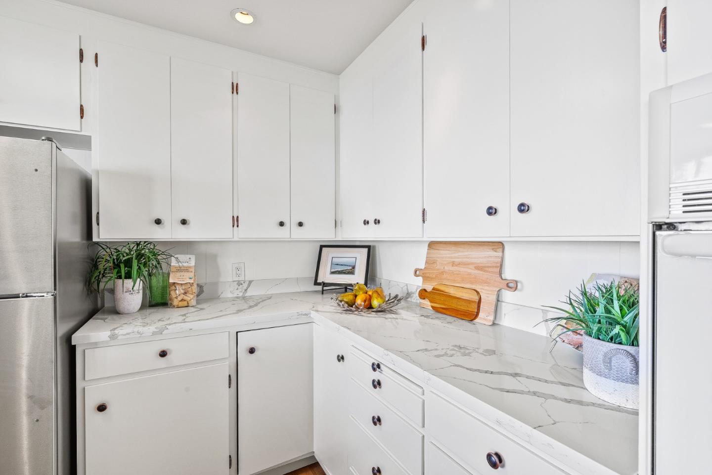 701 Seacliff Drive Aptos, CA 95003 - Photo 23 of 76 a kitchen with granite countertop white cabinets and white appliances
