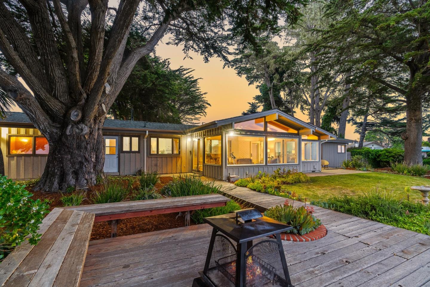 701 Seacliff Drive Aptos, CA 95003 - Photo 56 of 76 a backyard of a house with wooden floor table and chairs under an umbrella