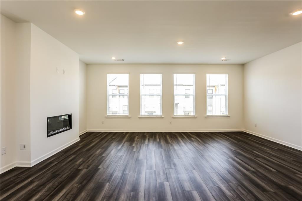 339 Sammon Way Lawrenceville, GA 30046 - Photo 6 of 20 an empty room with wooden floor and windows