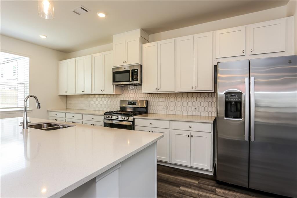 339 Sammon Way Lawrenceville, GA 30046 - Photo 10 of 20 a kitchen with stainless steel appliances granite countertop a refrigerator sink and white cabinets